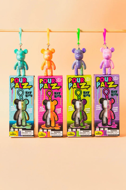 Pour Palz Mini Keyring Bear DIY Art Kits showing all 4 colour wave variants: teal, orange, purple and pink bears hanging above their boxes